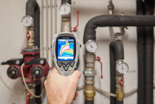 Plumber using a thermal imaging camera to inspect pipes in Cocoa